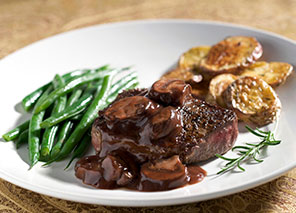 Plated meal with steak, green beans, roasted potatoes, and sauce, representing dining options and chef-prepared meals like at Milaca Elim Meadows