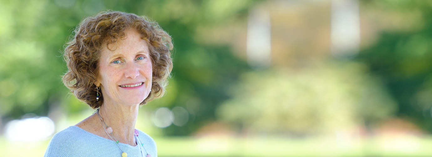 Employee portrait outdoors with a blurred green natural background, representing staff like at Milaca Elim Meadows