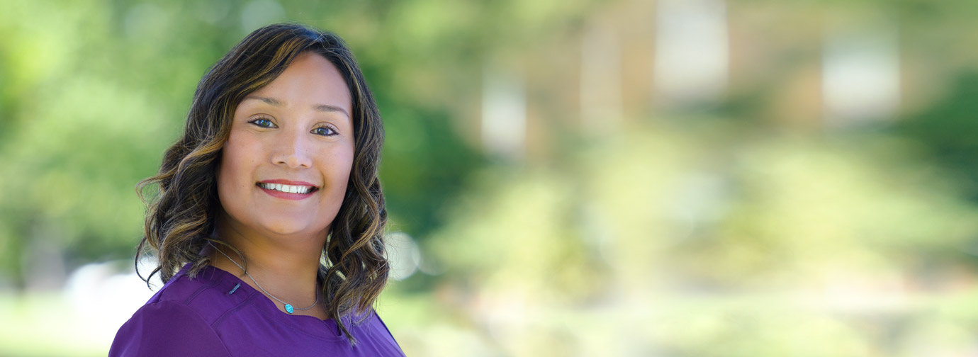 Employee portrait outdoors with a blurred green background, representing staff like at Milaca Elim Meadows