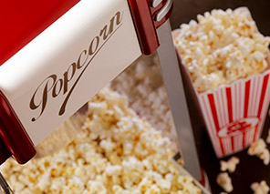 Popcorn machine with freshly popped popcorn and striped containers, representing movies, games, and entertainment activities like at Milaca Elim Meadows