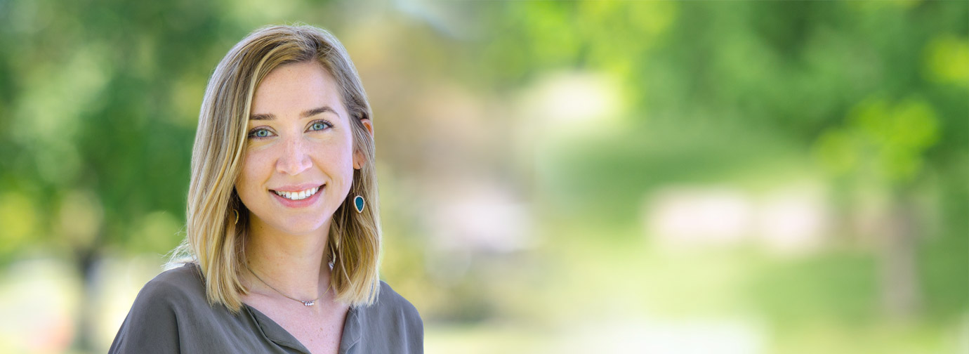 Close-up outdoor portrait of an adult with a blurred green background, representing welcoming staff and community lifestyle like at Milaca Elim Meadows