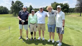 Five golfers pose together on the green during the 2026 Milaca Elim Meadows Golf Classic at Stones Throw Golf Course.